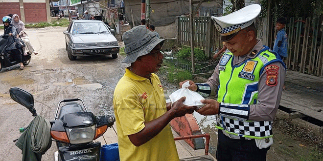 KBO-Lantas-Polres-Aceh-Utara,-Ipda-Irvan,-saat-membagikan-120-nasi-kotak.gif-2